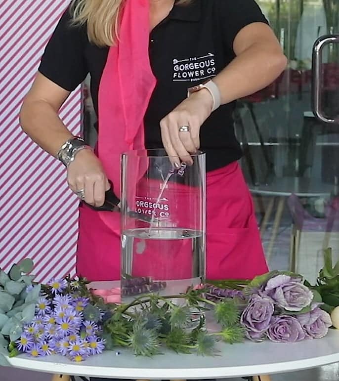 Sam demonstrating how to cut the stems and prepare your bouquet in a vase