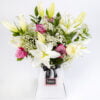 A gorgeous combination of White Lilies with White and Pink Roses and Gypsophelia in a vase by The gorgeous flower co